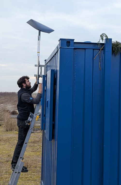 Starlink Rental UK fitter erecting a Sterlink dish at an outdoor event